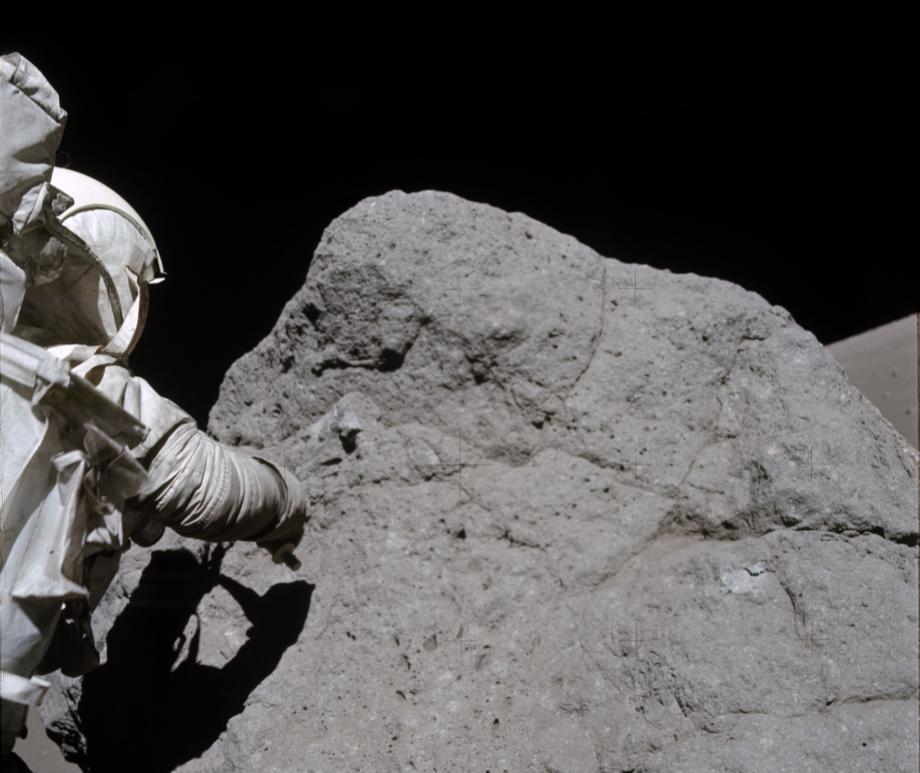 Apollo 17 Astronaut Harrison H. Schmitt samples the boulder at Station 7 located at the base of North Massif in the Taurus-Littrow valley