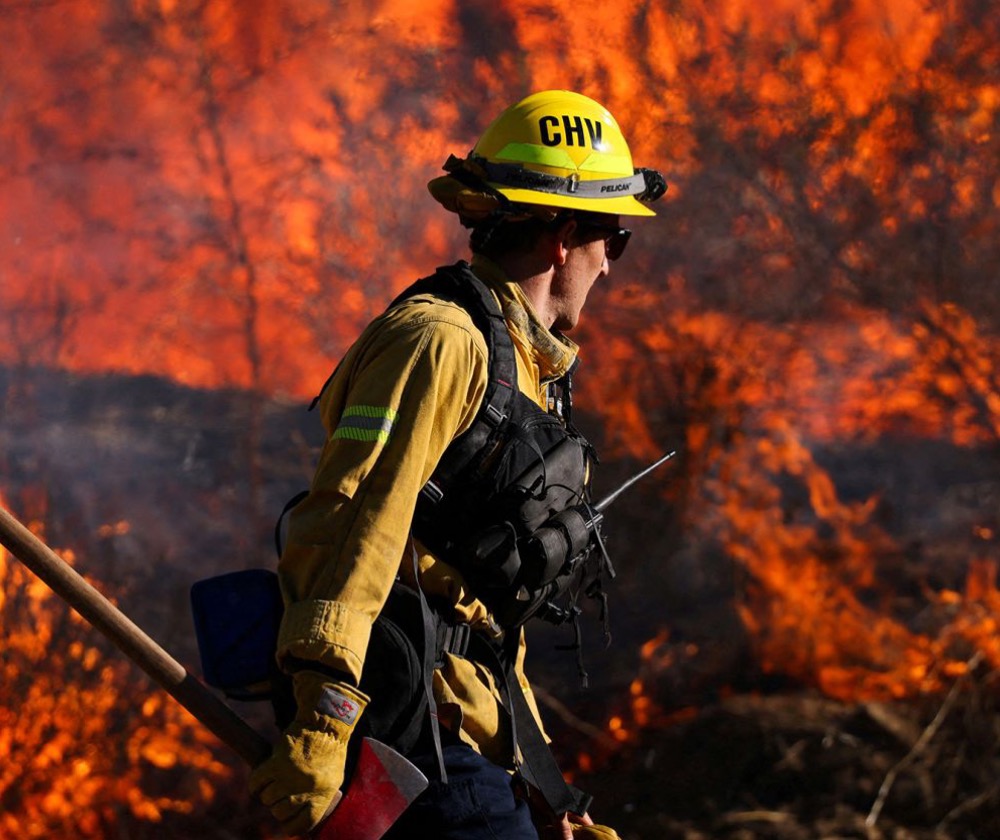 A firefighter works to extinguish the Highland Fire, a wildfire near Aguanga, California, October 31, 2023