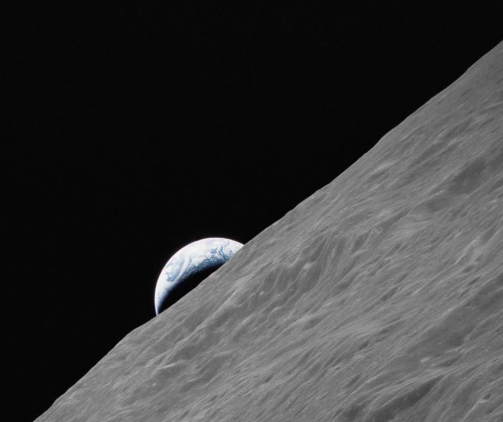 Earth rises above the lunar horizon in this photo taken from NASA's Apollo 17 spacecraft while in orbit during the Apollo program's final lunar landing mission