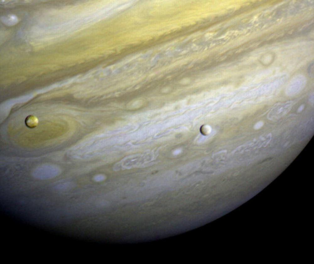 A nascent, coruscant Jupiter may have vaporized water from the surfaces of its moons, Io (shown on the left) and Europa (right)