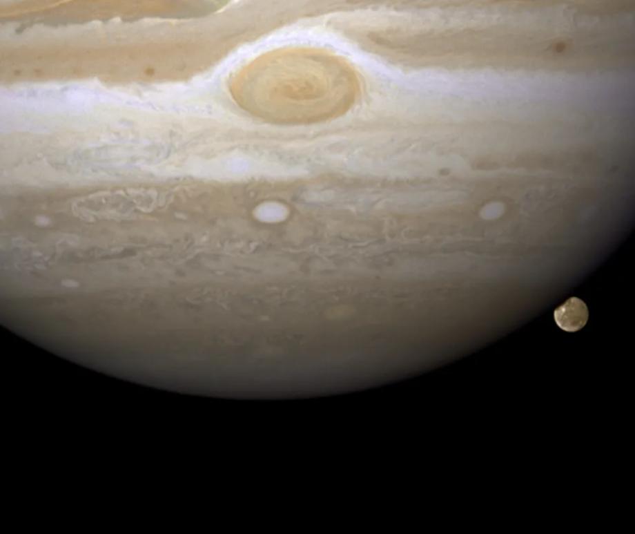 Jupiter’s largest moon, Ganymede, creeps out from behind the gas giant in this Hubble Space Telescope image