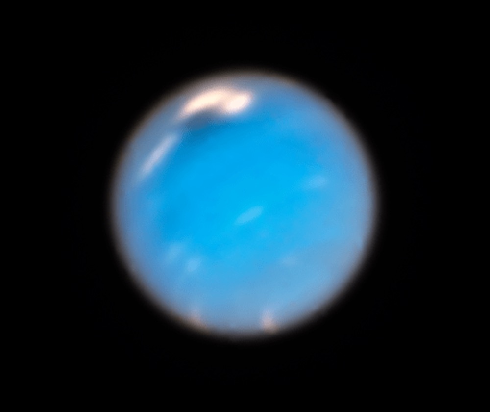 This Hubble Space Telescope Wide Field Camera 3 image of Neptune, taken in September and November 2018, shows a new dark storm (top center)