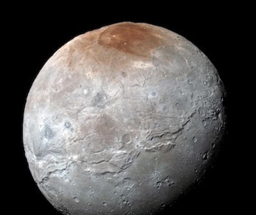 This enhanced-color version of a New Horizons photo of Charon shows Mordor Macula in red at the north pole, in stark contrast to the white and gray of the rest of Charon’s surface