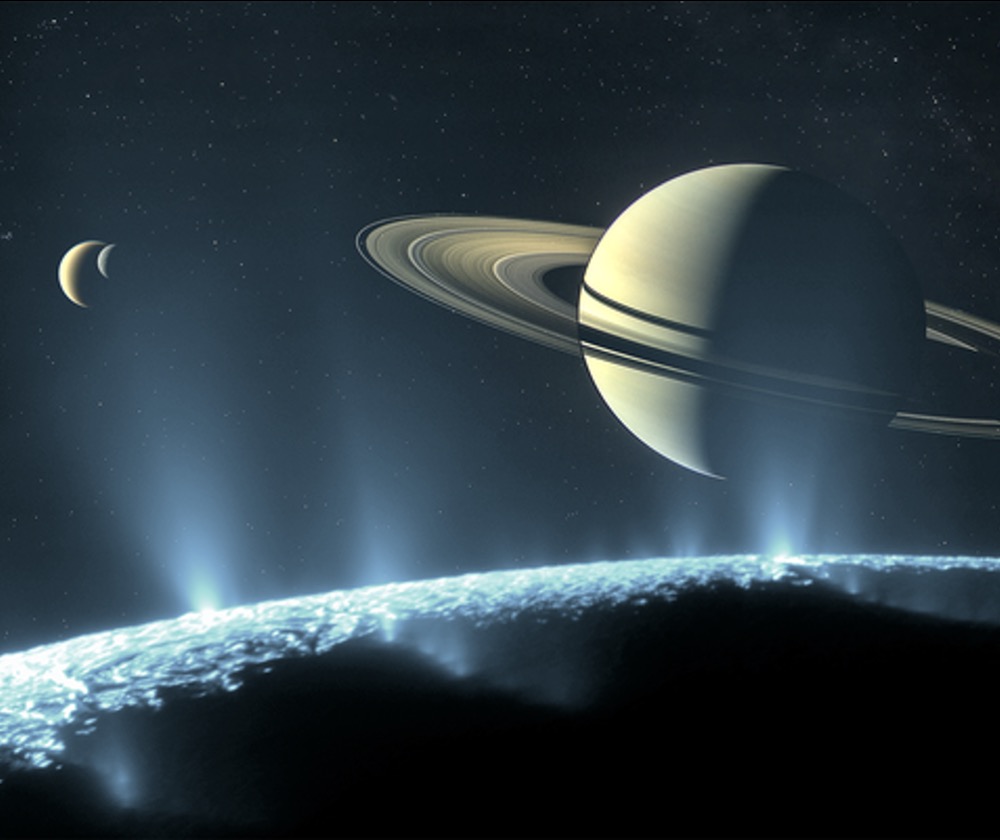 An artist’s conception of Saturn and its icy moons Enceladus (foreground), Titan (large crescent, upper left) and Rhea (small crescent, upper left) based on imagery from the Cassini spacecraft.