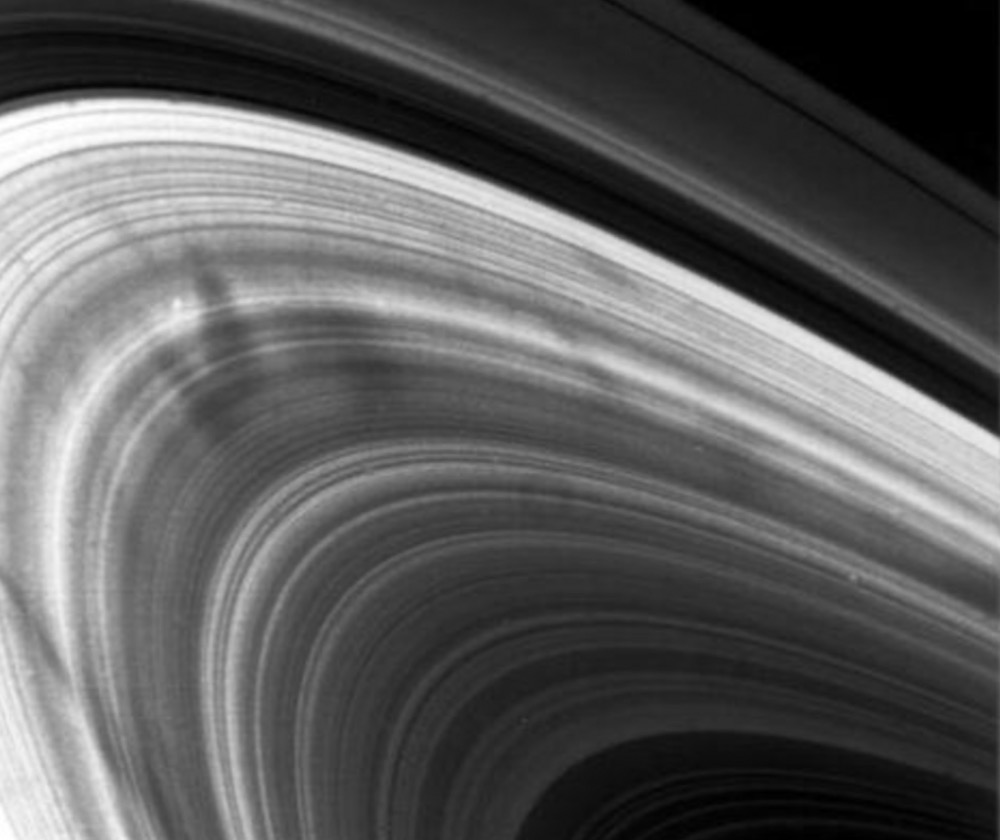 The dark “spokes” in Saturn’s rings, as 1st observed by the outbound Voyager 2 spacecraft on August 22, 1981