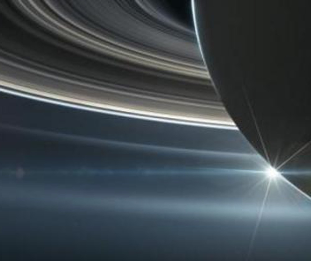 An image showing Saturn with the sun peeking out from behind