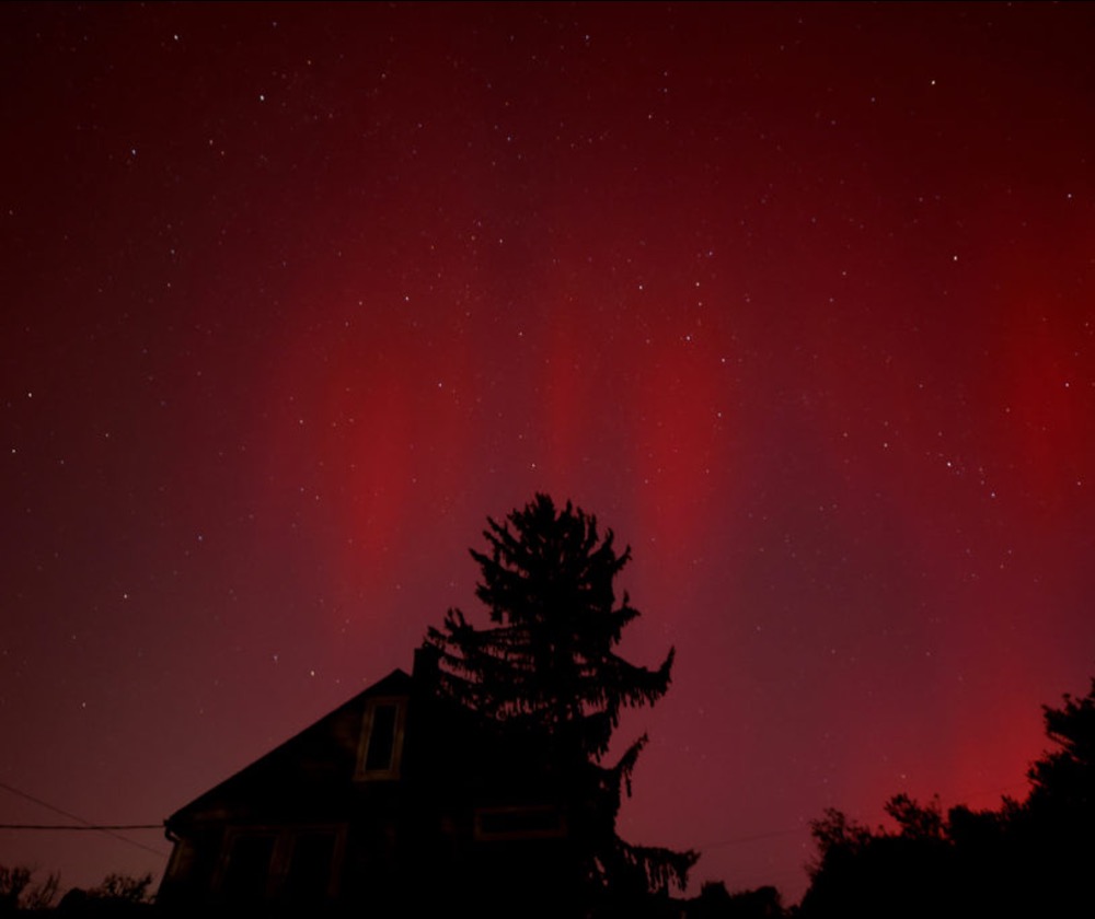 The aurora borealis, also referred to as northern lights, appear over a darkened neighborhood still without electricity nearly two weeks after Hurricane Helene, in Asheville, North Carolina, Oct. 10, 2024