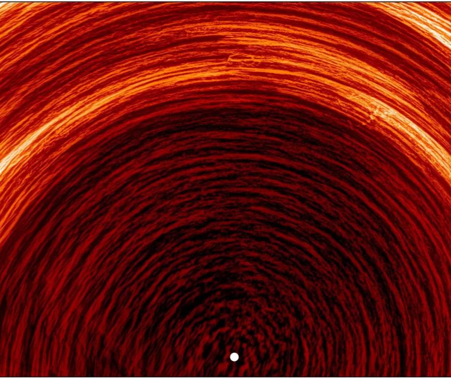 A processed image from ESA's Solar Orbiter shows the Sun's south pole (marked by the white dot). Bright arcs trace the motion of magnetic structures across the surface, created by combining eight days of observations from March 2025.